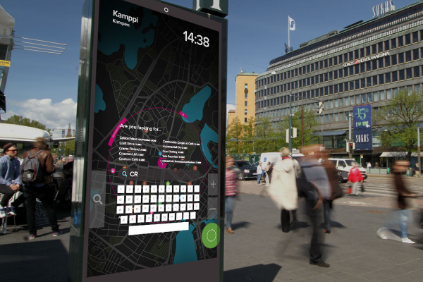 A situated urban display on a Helsinki street, with people walking past. A map is shown on the screen, with a search field and on-screen keyboard overlaid in the bottom half of the screen.